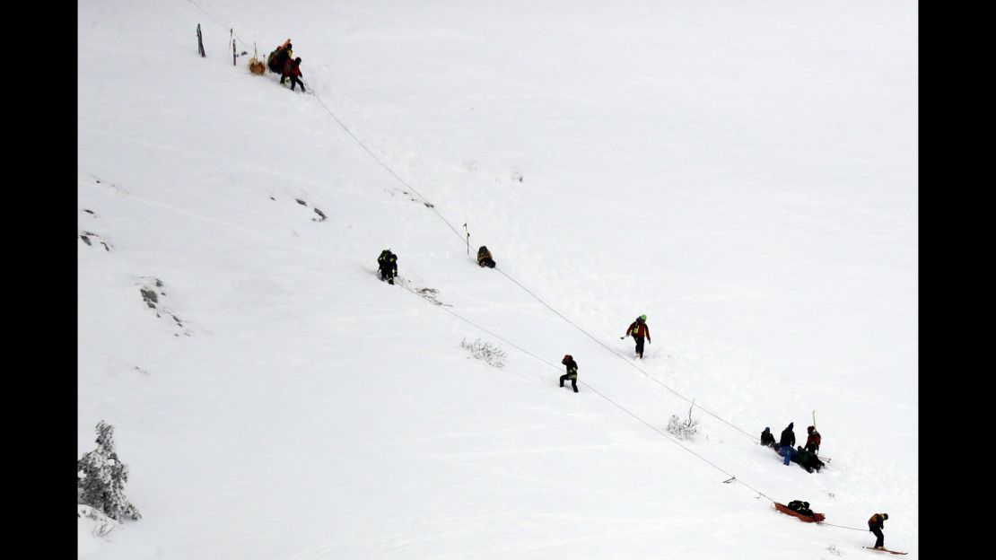 Rescuers work in the area where the helicopter crashed.