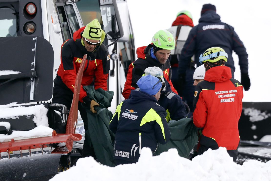 Rescuers carry away the body of one of the victims.