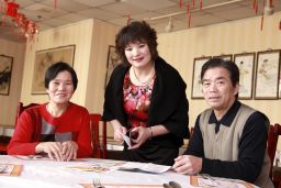 Outreach coordinator Xiangfen Gu, center, visits restaurant owners Qiu qi Li, left, and Mei zhen Dong on behalf of the Graham Cancer Center to stress the need for cancer screenings.