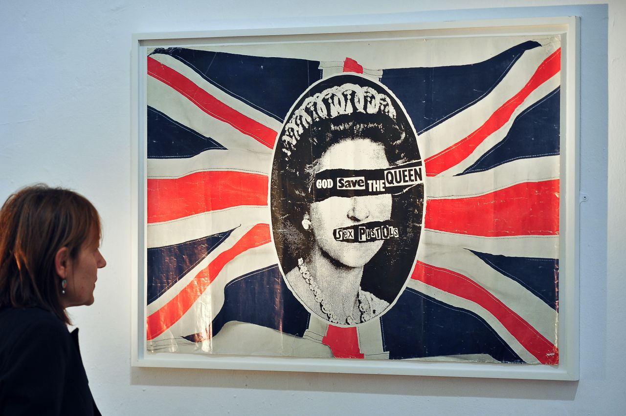 This provocative image was originally featured on promotional posters for the British punk rock band Sex Pistols' "God Save the Queen" single, released to coincide with the Queen's Silver Jubilee in 1977. Like the song's lyrics, the poster, design by British artist and anarchist Jamie Reid, was controversial at the time, but has since been reproduced on everything from mugs to jackets and shirts.<br />