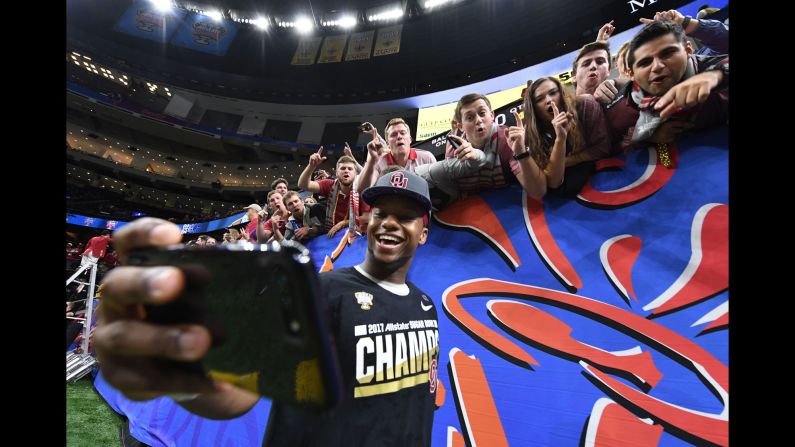 Oklahoma running back Joe Mixon takes selfies with fans after the Sooners' Sugar Bowl win in New Orleans on Monday, January 2.