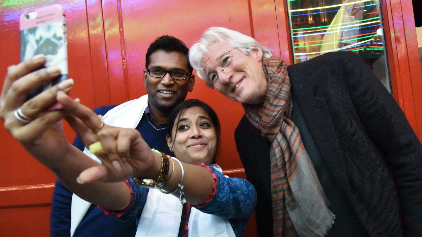 A fan takes a photo with actor Richard Gere, right, at a Buddhist meditation center in Bodh Gaya, India, on Thursday, January 12.