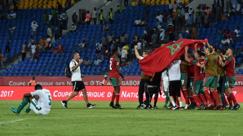 Joy and despair: Morocco's players celebrate, while the Ivory Coast's Wilfried Kanon sinks to the turf.