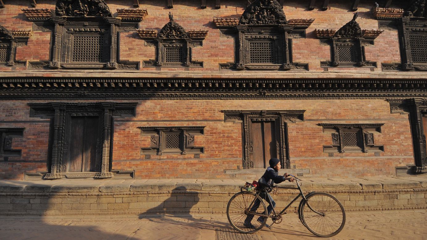 <strong>Kathmandu, Nepal:</strong> A child wheels his bike through UNESCO World Heritage site Bhaktapur Durbar Square, a former royal plaza filled with temples, statues and other landmarks. 