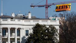 WASHINGTON, DC - JANUARY 25: With the White House in the foreground, protesters unfurl a banner atop a crane at the construction site of the former Washington Post office building, January 25, 2017 in Washington, DC. The protestors are with the Greenpeace organization.