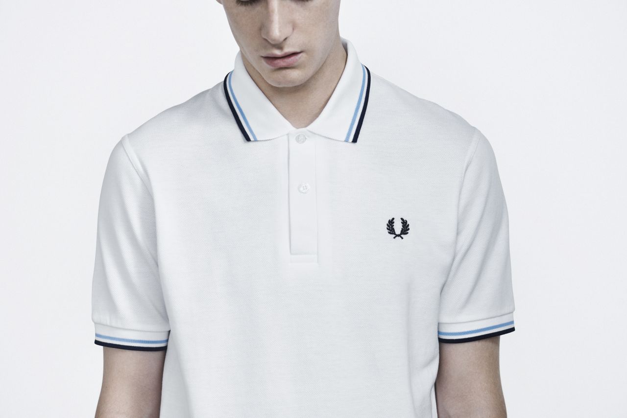 Launched at the Wimbledon tennis championship in 1952 and produced only in white for the first few years, designer and tennis champion Fred Perry's original M12 Fred Perry shirt, with the iconic sewn-in logo, was the first sports shirt with a tipped collar. Later favored by everyone from football fans in the 50s to mods and skinheads in the 60s and 70s, the now-classic design was among the first to make the crossover from sportswear to streetwear.<br />