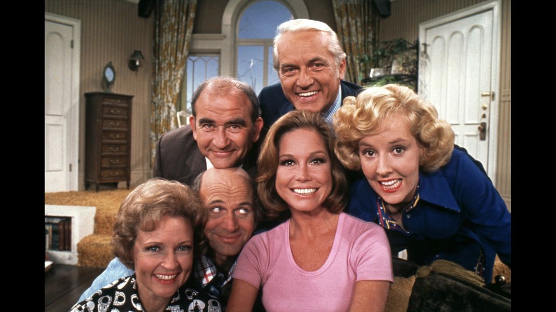 Moore, in the pink shirt, poses with cast members of "The Mary Tyler Moore Show" in 1974. Clockwise from Moore are Gavin MacLeod, Betty White, Ed Asner, Ted Knight and Georgia Engel. The show ended in 1977 but spurred several spinoffs, including "Rhoda" and "The Lou Grant Show."