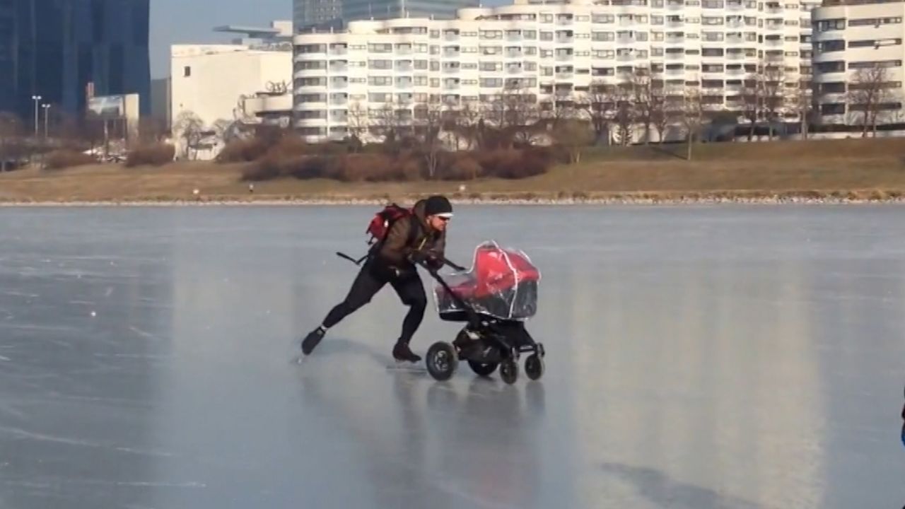 Man pushes buggy across frozen River Danube in Vienna