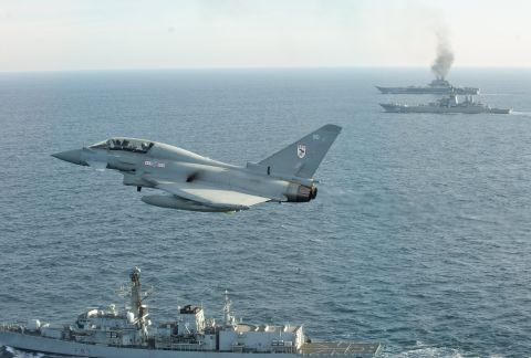 A Royal Air Force Typhoon fighter from Britain Quick Reaction Alert force flies near the Russian aircraft carrier Admiral Kuznetsov on Wednesday, January 25. The Russian carrier and a guided missile cruiser are on their way back home after participating in airstrikes in Syria. 