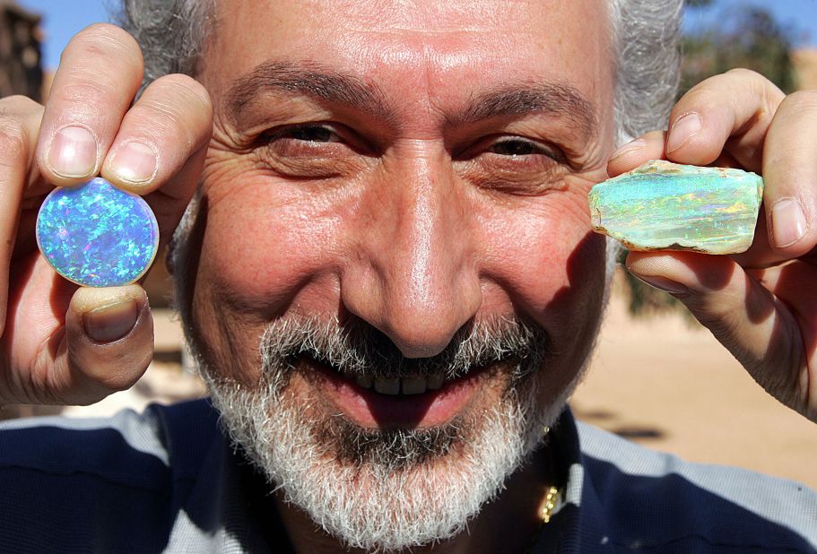 Here, an opal expert in Coober Pedy displays a harlequin crystal opal (left) and a boulder opal. 