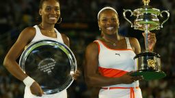 Serena Williams R) holds the winners trophy and her sister Venus Williams holds the runners up trophy after the women's singles final during the Australian Open at Melbourne Park on January 25, 2003.
