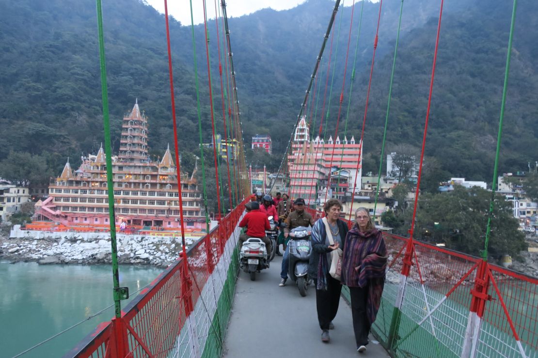 Pedestrians and motorists share a narrow path on Lakshman Jhula. 