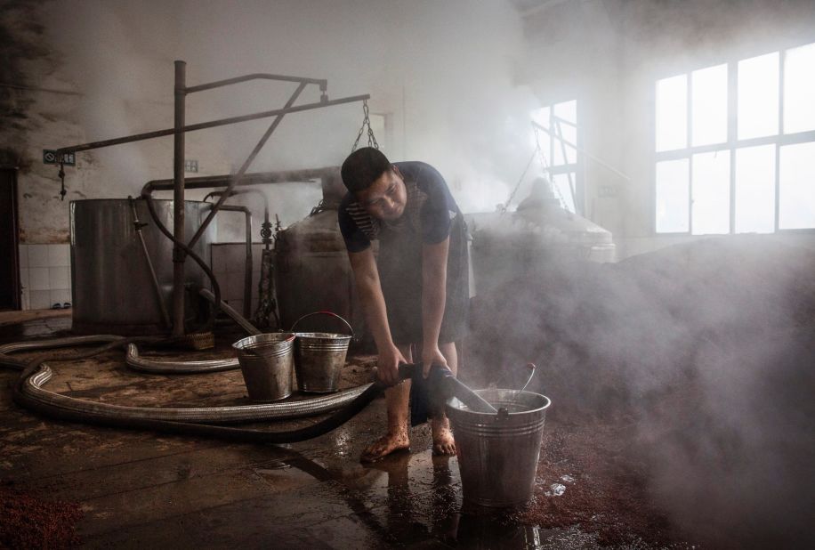 <strong>Labor intensive: </strong>A Chinese worker heats river water to be poured on the sorghum as it's prepared for fermentation.<br /> 