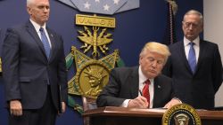 US President Donald Trump signs an executive order alongside US Defense Secretary James Mattis and US Vice President Muike Pence on January 27, 2016 at the Pentagon in Washington, DC.Trump signed an order Friday to begin what he called a "great rebuilding" of the US armed services, promising new aircraft, naval ships and more resources for the military. "Our military strength will be questioned by no one, but neither will our dedication to peace. We do want peace," Trump said in a ceremony at the Pentagon. / AFP / MANDEL NGAN        (Photo credit should read MANDEL NGAN/AFP/Getty Images)