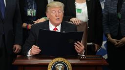 WASHINGTON, DC - JANUARY 25:  (AFP OUT) U.S. President Donald Trump (C) reads from one of the two executive orders he signed during a visit to the Department of Homeland Security January 25, 2017 in Washington, DC. Trump signed two executive orders related to domestic security and to begin the process of building a wall along the U.S.-Mexico border.  (Photo by Chip Somodevilla/Getty Images)