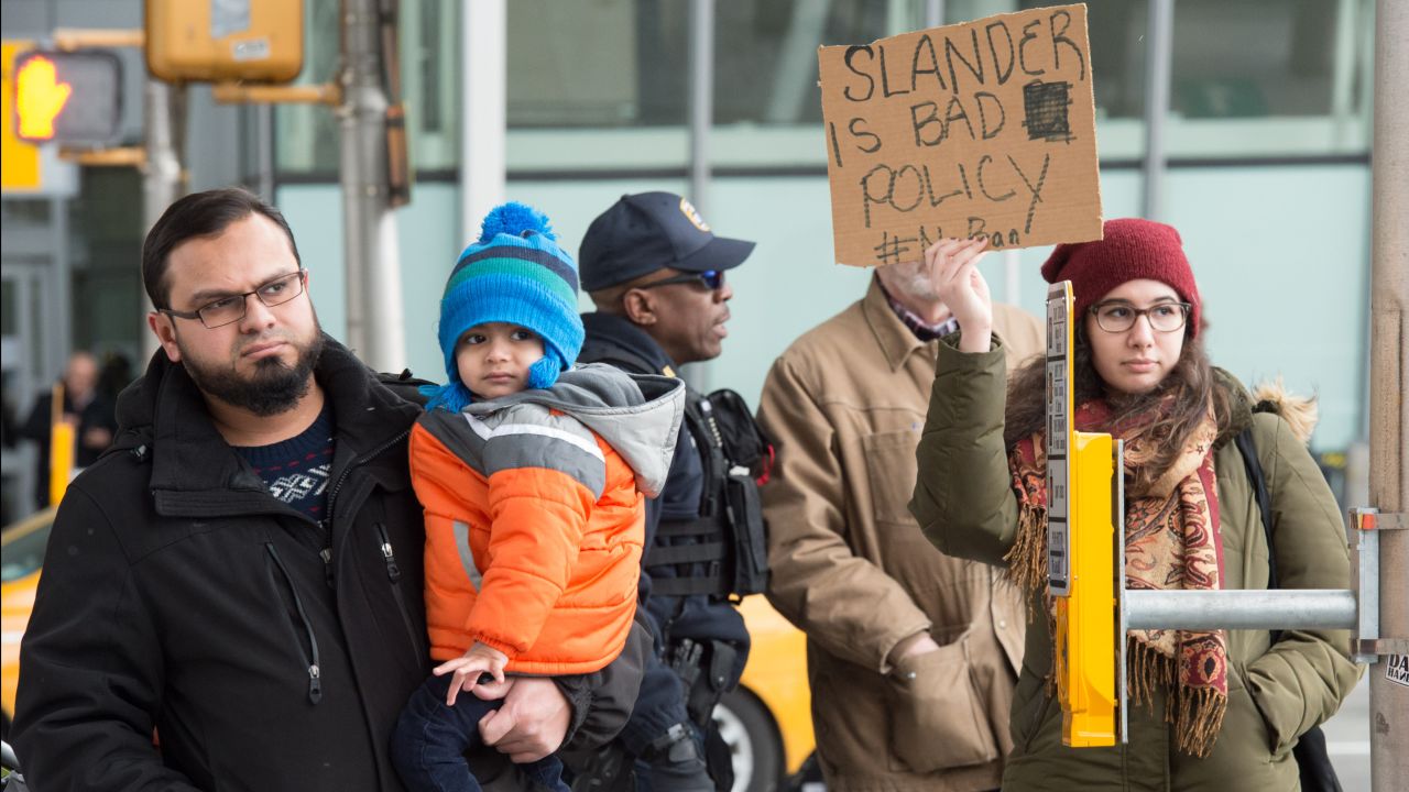 People arrive as protesters gather at JFK International Airport's Terminal 4 to demonstrate against US President Donald Trump's executive order, on January 28, 2016 in New York. Trump has signed a sweeping executive order to suspend refugee arrivals and impose tough controls on travellers from Iran, Iraq, Libya, Somalia, Sudan, Syria and Yemen.