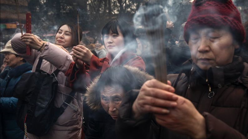 Worshippers pray for good luck and fortune on the first day of the Lunar New Year at the  Yonghe Temple in Beijing. 