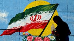 A Iranian woman walks past a wall painting in the shape of Iranian flag in Tehran, Iran on the first anniversary of nuclear deal between Iran and world powers on January 16, 2017.