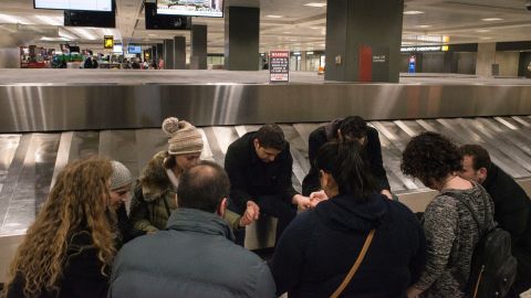 Hajouli prays with others while waiting for his wife