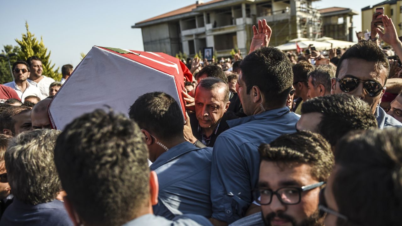 Turkey's President Recep Tayyip Erdogan carries a coffin of a victim of the coup attempt in Istanbul on July 17, 2016.