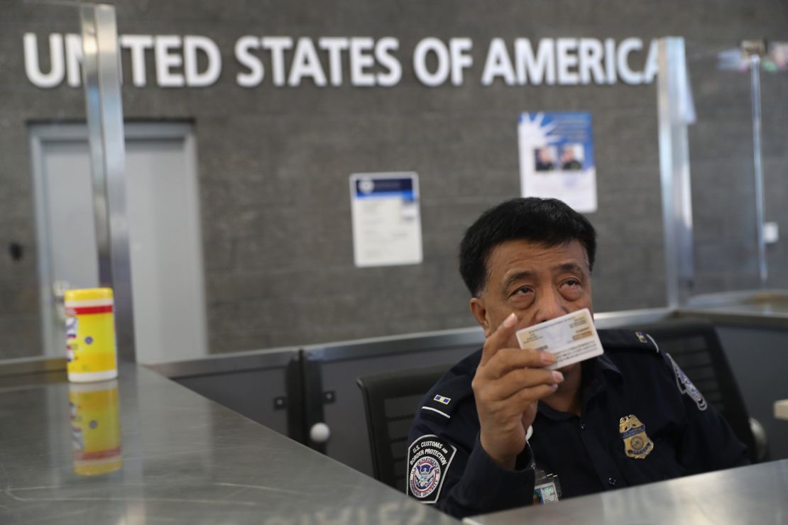 A Customs and Border Protection officer checks IDs as people enter the US from Mexico in San Ysidro, California. 