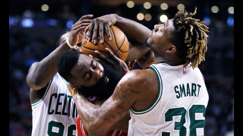 Houston guard James Harden, center, tries to hang onto the ball as he's guarded by Boston's Jae Crowder and Marcus Smart on Wednesday, January 25.