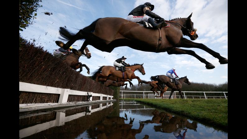 Horses clear a water jump during a race in Leicester, England, on Tuesday, January 24.