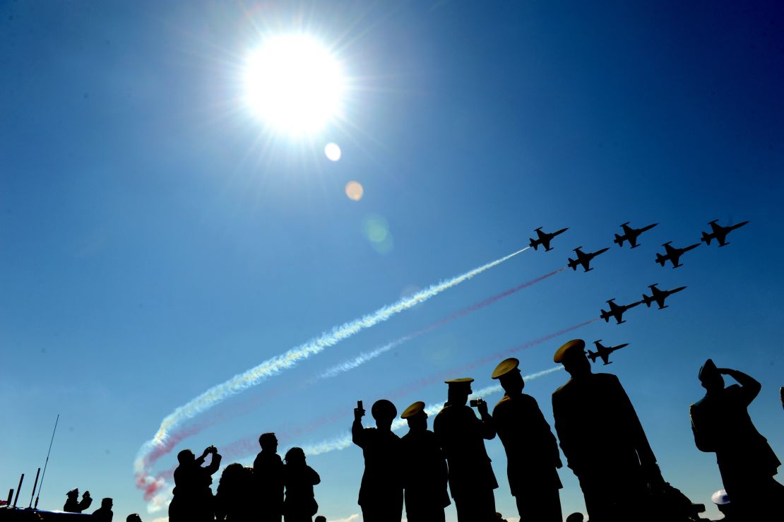 Turkish air force patrollers fly by as  soldiers watch during a ceremony in April 2011.