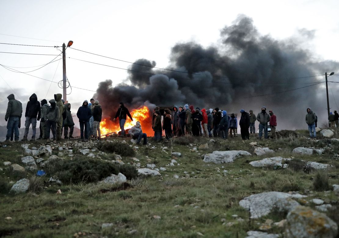Settlers set tires ablaze at the Amona outpost as Israeli security forces prepare to evict occupants.