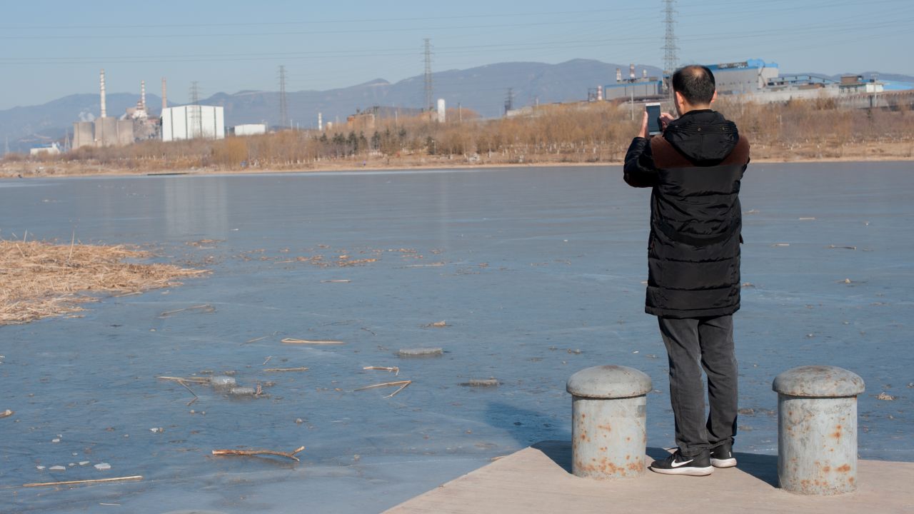 Environmental activist Ma Jun uses his smartphone to upload photos of a disused steel plant to his anti-pollution app on January 18.