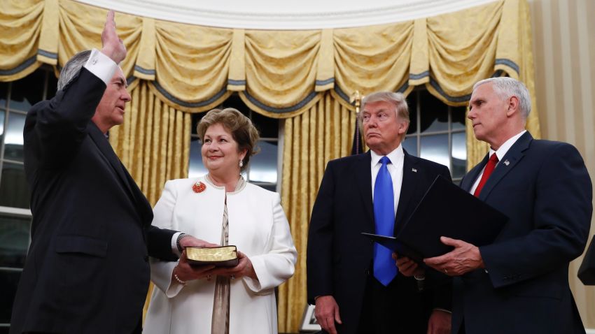 President Donald Trump watches as Vice President Mike Pence swears in Rex Tillerson as Secretary of State in the Oval Office of the White House in Washington, Wednesday, Feb. 1, 2017. Holding the Bible is Tillerson's wife Renda St. Clair. (AP Photo/Carolyn Kaster)