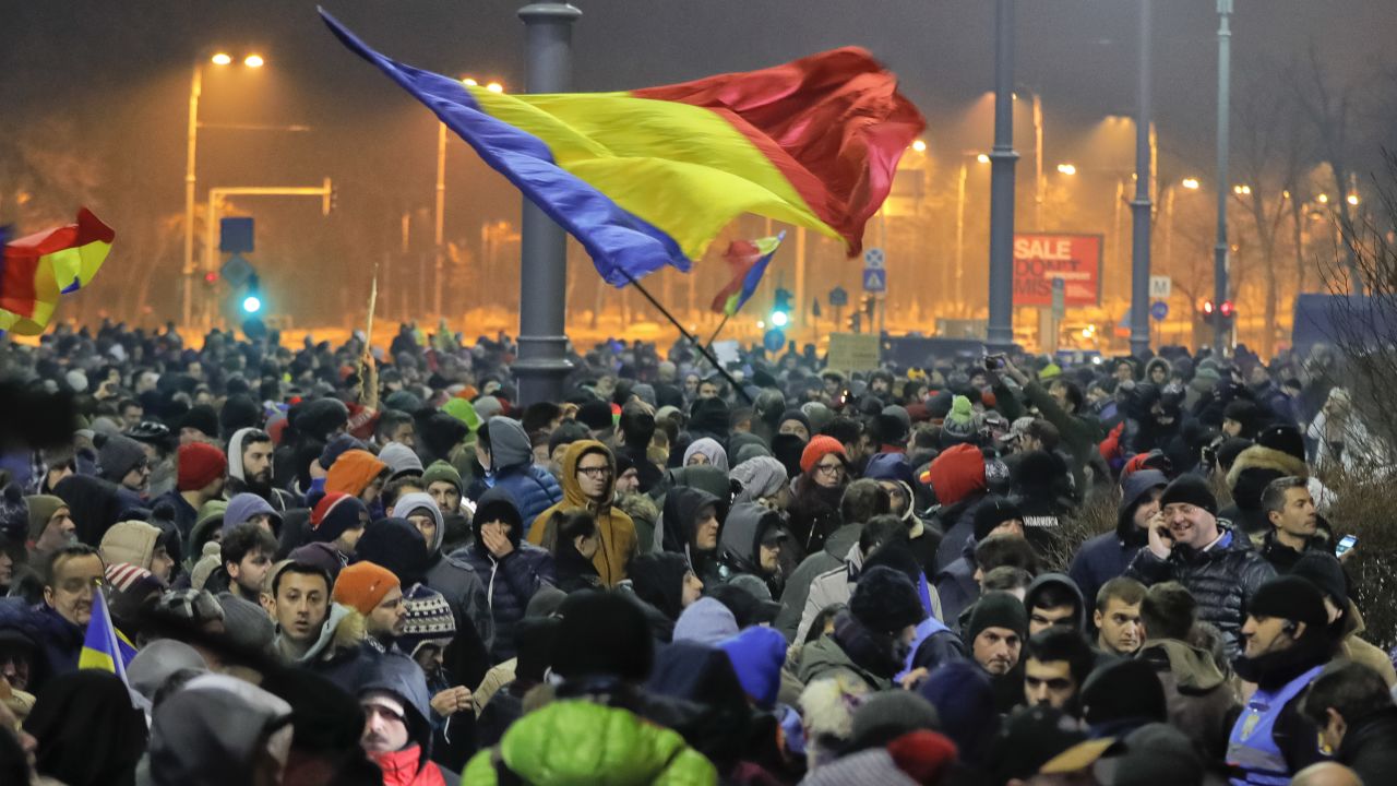 Many protesters wave Romanian flags or hold up signs Wednesday in Bucharest.