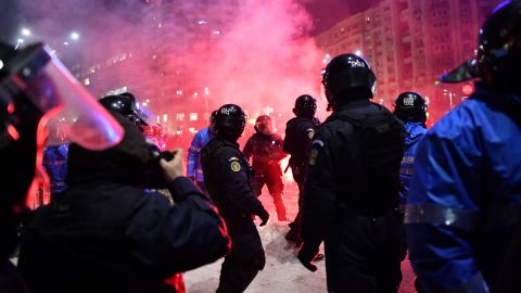 Riot police clash with protesters Wednesday in front of government headquarters in Bucharest.