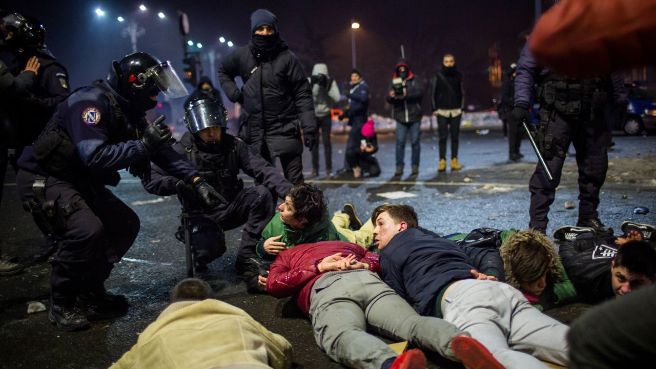 Riot police detain some protesters Wednesday in Bucharest. 