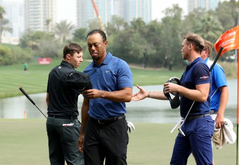 A dejected-looking Woods leaves the ninth green at the end of his first round as playing partners Matthew Fitzpatrick and Masters champion Danny Willett of England shake hands behind him. 
