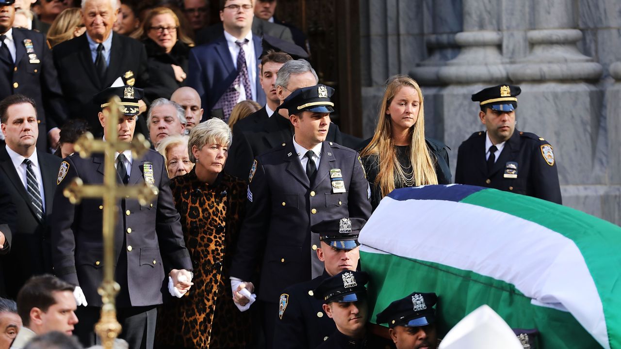 Patti Ann McDonald and son Conor follow Steven McDonald's casket at his funeral last month.