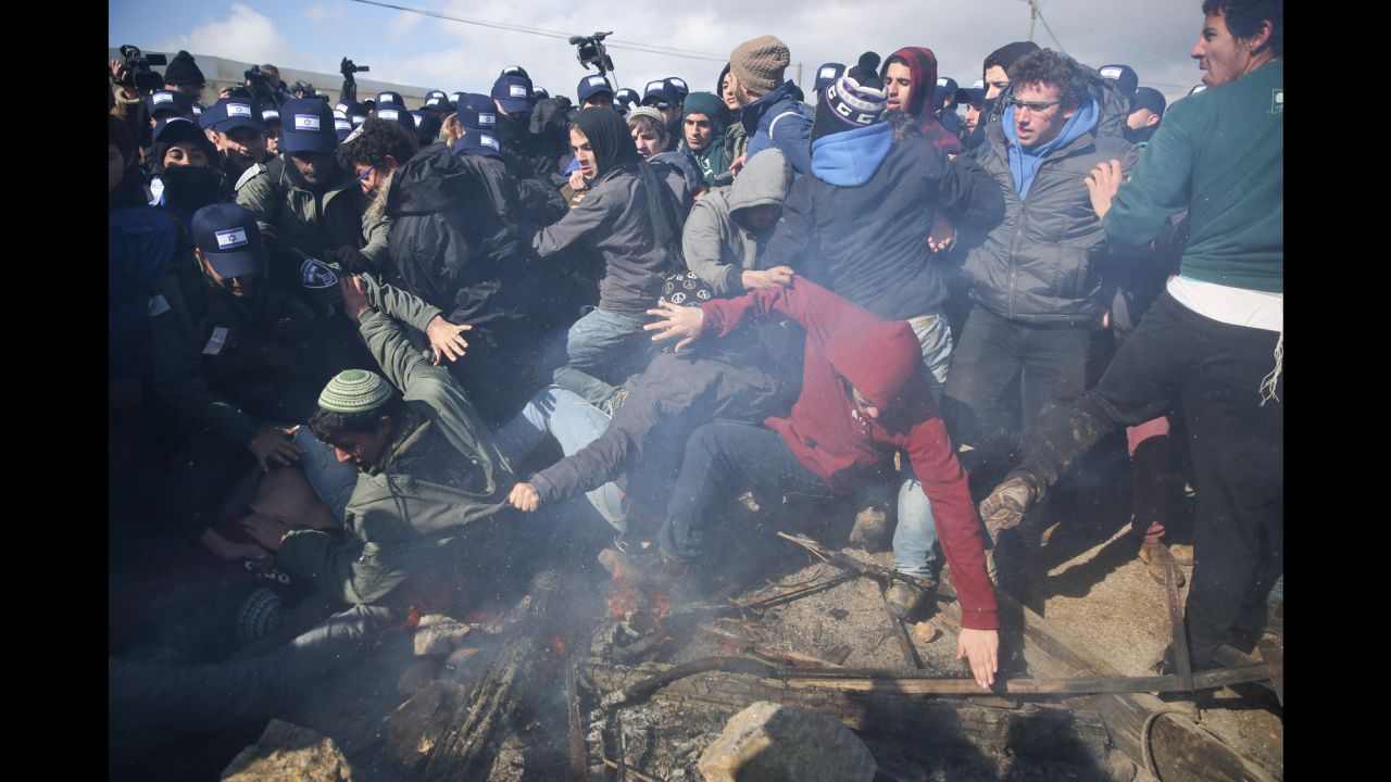 Israeli police clash with settlers in the West Bank outpost of Amona, Wednesday, Feb. 1, 2017. Israeli forces have begun evacuating a controversial settlement  Amona, which is the largest of about 100 unauthorized outposts erected in the West Bank without permission but generally tolerated by the Israeli government. (AP Photo/Oded Balilty)