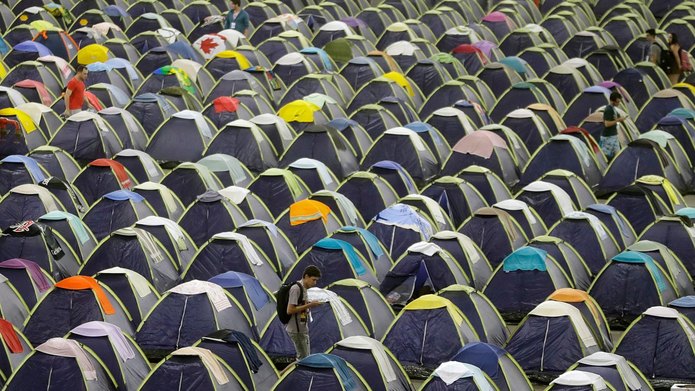 A participant walks between rows of tents in the camping area of Campus Party in Sao Paulo, Brazil, on Wednesday, February 1. According to its website, Campus Party is an annual weeklong, 24-hour-a-day technological experience that brings together developers, gamers and hackers for a festival geared toward innovation, creativity, science and entrepreneurship entertainment.