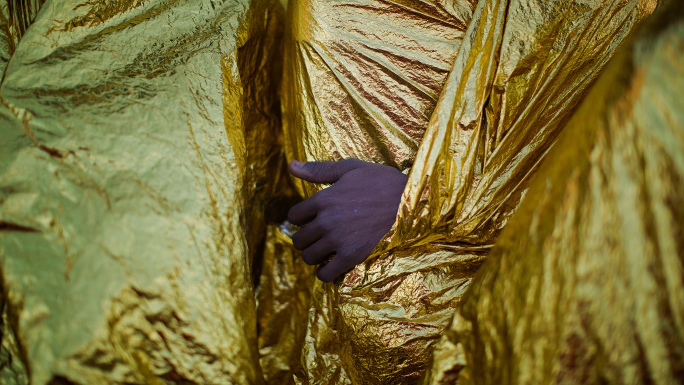 A migrant's hand is seen outside a blanket while on the deck of the Golfo Azzurro rescue vessel after arriving at the port of Messina, Italy, on Sunday, January 29.