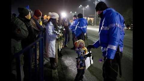 A young girl offers a flower to a police officer during an anti-government protest February 2 in Bucharest.