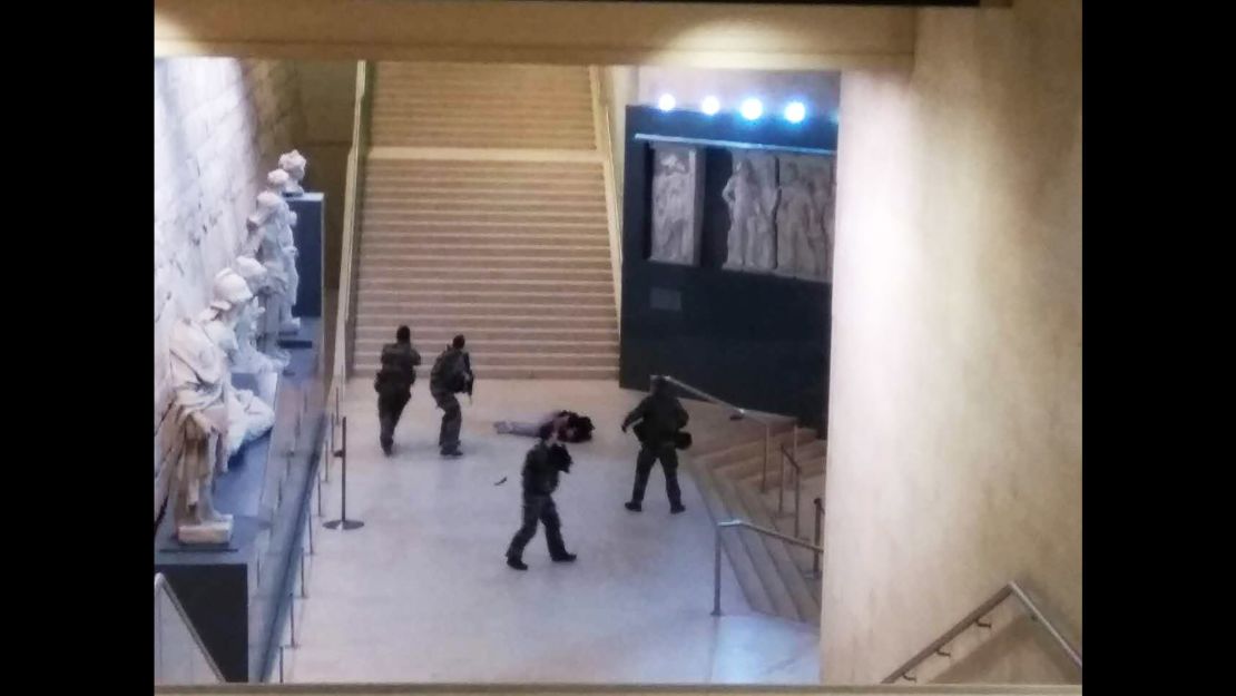 A picture taken by a tourist on a mobile phone shows a soldier opening fire at an entry to the Louvre.