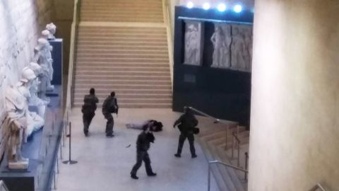 A picture taken by a tourist on a mobile phone shows a soldier opening fire at an entry to the Louvre.