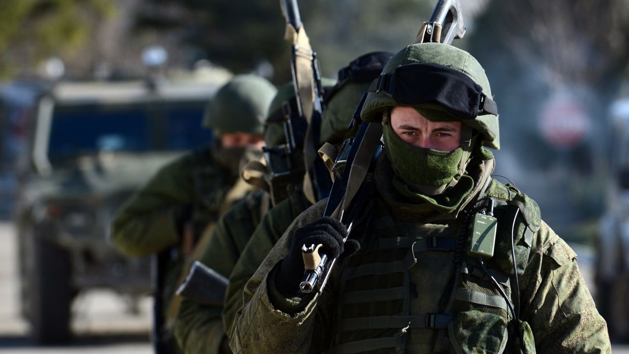 Armed men, believed to be Russian servicemen, patrol outside an Ukrainian military base in Perevalnoye on March 17, 2014. The United States and Europe aimed sanctions directly at Vladmir Putin's inner circle Monday to punish Russia's move to annex Crimea, deepening the worst East-West rift since the Cold War. The move came hours after the Ukrainian regime voted to join Russia in a referendum the West deems illegitimate and as Crimea embarked on the next political steps to embrace Kremlin rule. AFP PHOTO/ VASILY MAXIMOV        (Photo credit should read VASILY MAXIMOV/AFP/Getty Images)