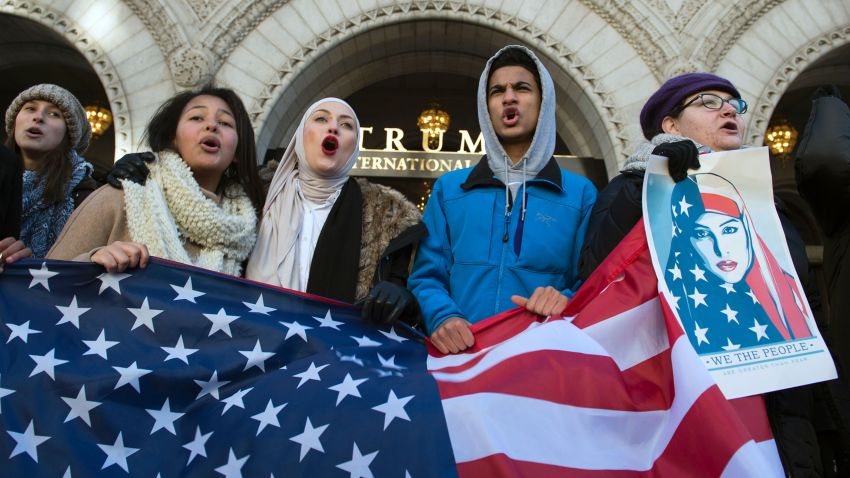 Protesters hold an US Flag while protesting outside the Trump Hotel on February 4, 2017, in Washington, DC. The demonstrators protested US President Donald Trump's travel ban on nationals from seven Muslim-majority countries.
