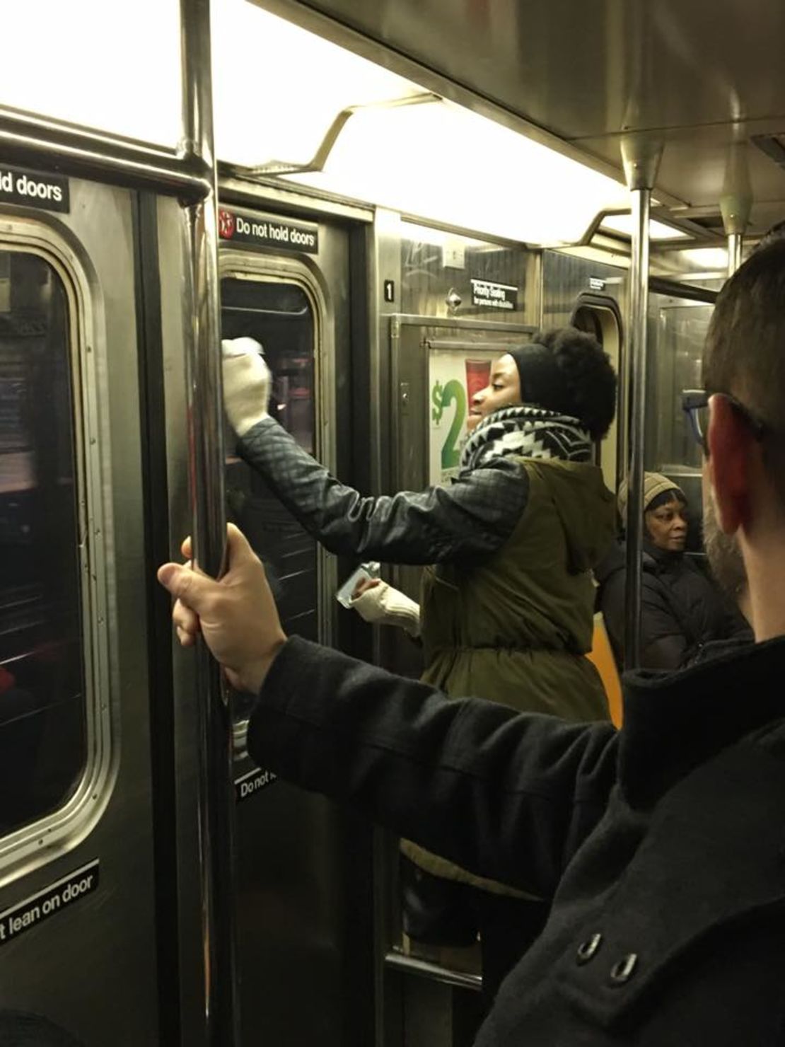 Another passenger helps to remove the graffiti from the train.