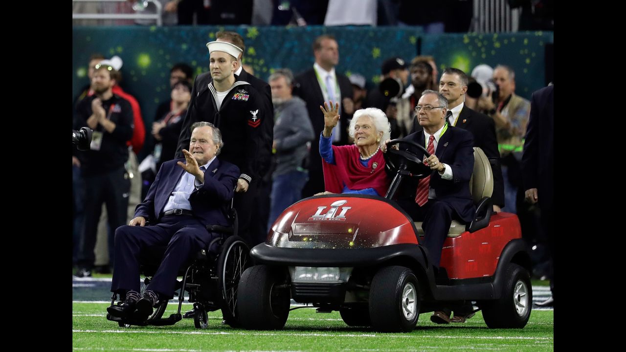 Former President George H.W. Bush and his wife, Barbara, wave as they arrive for the pregame coin toss. <a href="http://www.cnn.com/2017/01/30/politics/former-president-george-h-w-bush-released-from-hospital/" target="_blank">They were both recently hospitalized.</a>