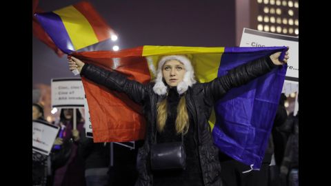 A woman displays a Romanian flag during a protest in Bucharest on Friday, February 3.
