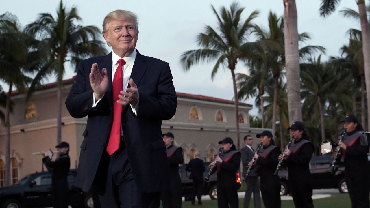 President Donald Trump listens to the Palm Beach Central High School Band as they play at his arrival at Trump International Golf Club in West Palm Beach, Florida Sunday, February 5, 2017.