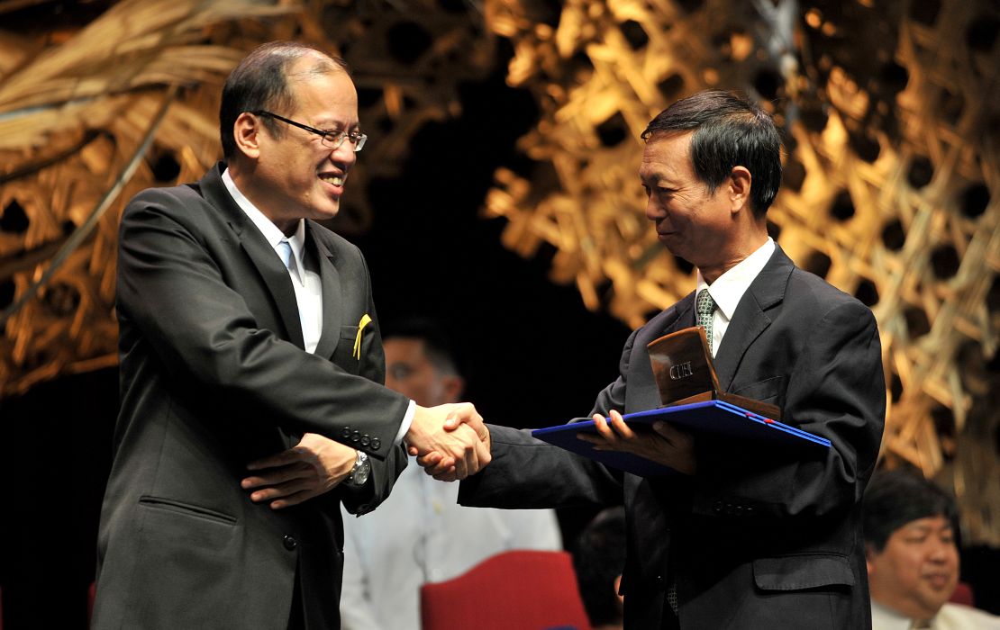 Huo Daishan (R) shakes hands with Philippine President Benigno Aquino on August 31, 2010, during a ceremony honoring him for his environmental work.