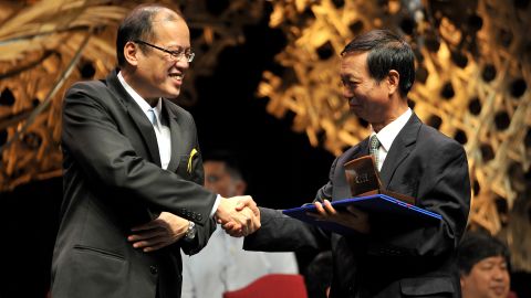 Huo Daishan (R) shakes hands with Philippine President Benigno Aquino on August 31, 2010, during a ceremony honoring him for his environmental work.